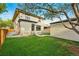View of the home's backyard with detached garage, new fence, and manicured lawn at 2391 Hudson St, Denver, CO 80207