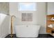 Modern bathroom with a freestanding tub, gold hardware, and tiled accent wall at 2391 Hudson St, Denver, CO 80207