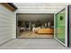 Open-concept living space featuring bi-fold doors, hardwood floors, a modern kitchen, and a stylish living room at 2391 Hudson St, Denver, CO 80207