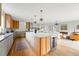 Open-concept kitchen featuring a large island, modern appliances, wood cabinetry, and seamless flow to the living area at 2391 Hudson St, Denver, CO 80207