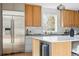 Close-up of a modern kitchen with stainless steel appliances, wood cabinets, marble backsplash, and a large center island at 2391 Hudson St, Denver, CO 80207