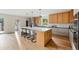 Bright and open kitchen featuring a large center island with seating, wood cabinetry, and modern appliances at 2391 Hudson St, Denver, CO 80207