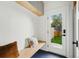 Functional mud room with built-in bench, storage shelf, and a door leading to a fenced backyard at 2391 Hudson St, Denver, CO 80207