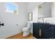 Elegant powder room featuring a modern vanity, stylish mirror, and hardwood floors at 2391 Hudson St, Denver, CO 80207