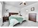 This bedroom features a wood headboard, ceiling fan, and carpet at 56375 E 22Nd Pl, Strasburg, CO 80136