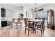 Cozy dining area features hardwood floors, a decorative chandelier, and seamless transition into the open-concept kitchen at 56375 E 22Nd Pl, Strasburg, CO 80136