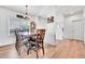 Bright dining area features a wooden table with seating for six, modern lighting, and hardwood floors at 56375 E 22Nd Pl, Strasburg, CO 80136