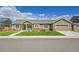 Charming single-story home features a two-car garage, covered porch, stone accents, and a well-maintained lawn at 56375 E 22Nd Pl, Strasburg, CO 80136