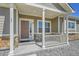 Inviting front porch featuring stone accents, white columns, and a charming front door, perfect for relaxing outdoors at 56375 E 22Nd Pl, Strasburg, CO 80136