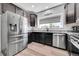 Modern kitchen features stainless steel appliances, granite counters, dark cabinets, and hardwood floors for a stylish look at 56375 E 22Nd Pl, Strasburg, CO 80136