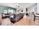 Open-concept living room with hardwood floors, a ceiling fan, and comfortable leather seating, perfect for relaxation at 56375 E 22Nd Pl, Strasburg, CO 80136