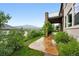 Scenic backyard features a stone patio, lush greenery, and mountain views at 15377 W Iliff Dr, Denver, CO 80228