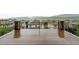 Spacious deck features black metal railings and stone posts with mountain views in the background at 15377 W Iliff Dr, Denver, CO 80228