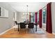 Stylish dining room with hardwood floors, red curtains, and modern lighting fixtures at 15377 W Iliff Dr, Denver, CO 80228