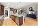 Open concept kitchen with stainless appliances, hardwood floors, and a view of the living room at 15377 W Iliff Dr, Denver, CO 80228