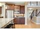 Kitchen with stainless steel fridge and granite countertops with a view of the stairwell at 15377 W Iliff Dr, Denver, CO 80228