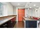 Modern kitchen features granite counters, wood floors, and a stylish red sliding barn door at 15377 W Iliff Dr, Denver, CO 80228