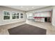 Open-concept living room with bright windows, tiled floors, and kitchen in the background at 15377 W Iliff Dr, Denver, CO 80228