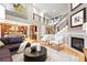 Stylish living room with hardwood floors, fireplace, and seamless flow to the kitchen and dining areas at 15377 W Iliff Dr, Denver, CO 80228