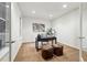 Modern office with neutral walls, accent art, and dual leather poufs at 15377 W Iliff Dr, Denver, CO 80228