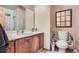 Bathroom featuring a wooden vanity, mirror, and toilet with accessibility bars for convenience at 754 Highway 86 Hwy, Elizabeth, CO 80107