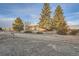 Exterior shot of a cozy home featuring mature trees and a spacious yard at golden hour at 754 Highway 86 Hwy, Elizabeth, CO 80107