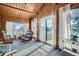 Bright sunroom with wood paneling, large windows, and comfortable seating for relaxation and enjoying the view at 754 Highway 86 Hwy, Elizabeth, CO 80107