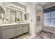 Bathroom features a dual sink vanity, tile floors, and large mirror with vanity lighting at 3792 S Dallas St, Aurora, CO 80014