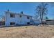 A spacious backyard with a two-story blue house, stairs leading to the upper level, and outdoor seating area at 15640 E Eldorado Dr, Aurora, CO 80013