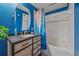 Stylish bathroom featuring a wooden vanity, overhead lighting, and vibrant blue walls at 7413 S Quail Cir # 1435, Littleton, CO 80127
