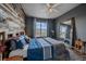 Bedroom featuring wood accent wall, large mirror, ceiling fan, and plush carpeting at 7413 S Quail Cir # 1435, Littleton, CO 80127