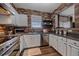 Modern kitchen with stainless steel appliances, brick accent wall, and sleek countertops at 7413 S Quail Cir # 1435, Littleton, CO 80127