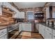 Modern kitchen featuring stainless steel appliances, white cabinets, and brick backsplash at 7413 S Quail Cir # 1435, Littleton, CO 80127