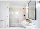 Bright bathroom featuring a sleek glass shower, decorative gold fixtures and a crisp white pedestal sink at 3249 W Fairview Pl # 207, Denver, CO 80211