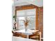 Bright dining area with exposed brick, modern table, and large window with natural light at 3249 W Fairview Pl # 207, Denver, CO 80211