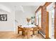 Dining area with modern white table, chairs, exposed brick wall, and hardwood floors at 3249 W Fairview Pl # 207, Denver, CO 80211