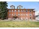 A brick apartment building with three stories and a grassy front yard offers a blend of classic style and outdoor space at 3249 W Fairview Pl # 207, Denver, CO 80211