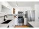 Updated kitchen featuring stainless steel appliances, white cabinets, and modern fixtures at 3249 W Fairview Pl # 207, Denver, CO 80211