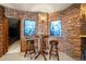 Cozy basement nook with a stone wall, two bar stools, and dim lighting perfect for casual conversation at 19205 Sixpenny Ln, Monument, CO 80132