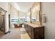 Luxurious bathroom featuring stone accent wall, soaking tub, and double sink vanity with granite counters at 19205 Sixpenny Ln, Monument, CO 80132