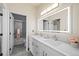 Well-lit bathroom with double vanity, modern lighting, and a glass enclosed shower visible in the mirror at 19205 Sixpenny Ln, Monument, CO 80132