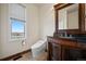 Bathroom featuring an antique vanity with dark wood and granite counters, a window with an outdoor view at 19205 Sixpenny Ln, Monument, CO 80132