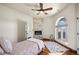 Cozy bedroom featuring a fireplace, unique window, and hardwood floors; perfect for relaxation at 19205 Sixpenny Ln, Monument, CO 80132