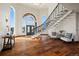 Bright and airy foyer featuring hardwood floors, a winding staircase, and large windows providing ample natural light at 19205 Sixpenny Ln, Monument, CO 80132