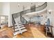 Elegant foyer showcases a curved staircase, hardwood floors, and a glimpse into the open-concept living spaces at 19205 Sixpenny Ln, Monument, CO 80132