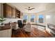 Spacious home office featuring custom cabinetry, hardwood floors, and abundant natural light from large windows at 19205 Sixpenny Ln, Monument, CO 80132