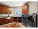 Functional laundry room with ample counter space, custom cabinets, sink, and modern washer/dryer units at 19205 Sixpenny Ln, Monument, CO 80132