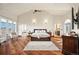 Bright main bedroom features wood floors, a vaulted ceiling, and a seating area with lots of natural light at 19205 Sixpenny Ln, Monument, CO 80132