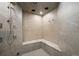 Modern tile shower with built-in bench seating and multiple shower heads, perfect for a spa-like experience at 19205 Sixpenny Ln, Monument, CO 80132