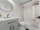 Bright bathroom featuring a white vanity, a black faucet, a round mirror and a shower with patterned curtains at 19792 E Bates Dr, Aurora, CO 80013